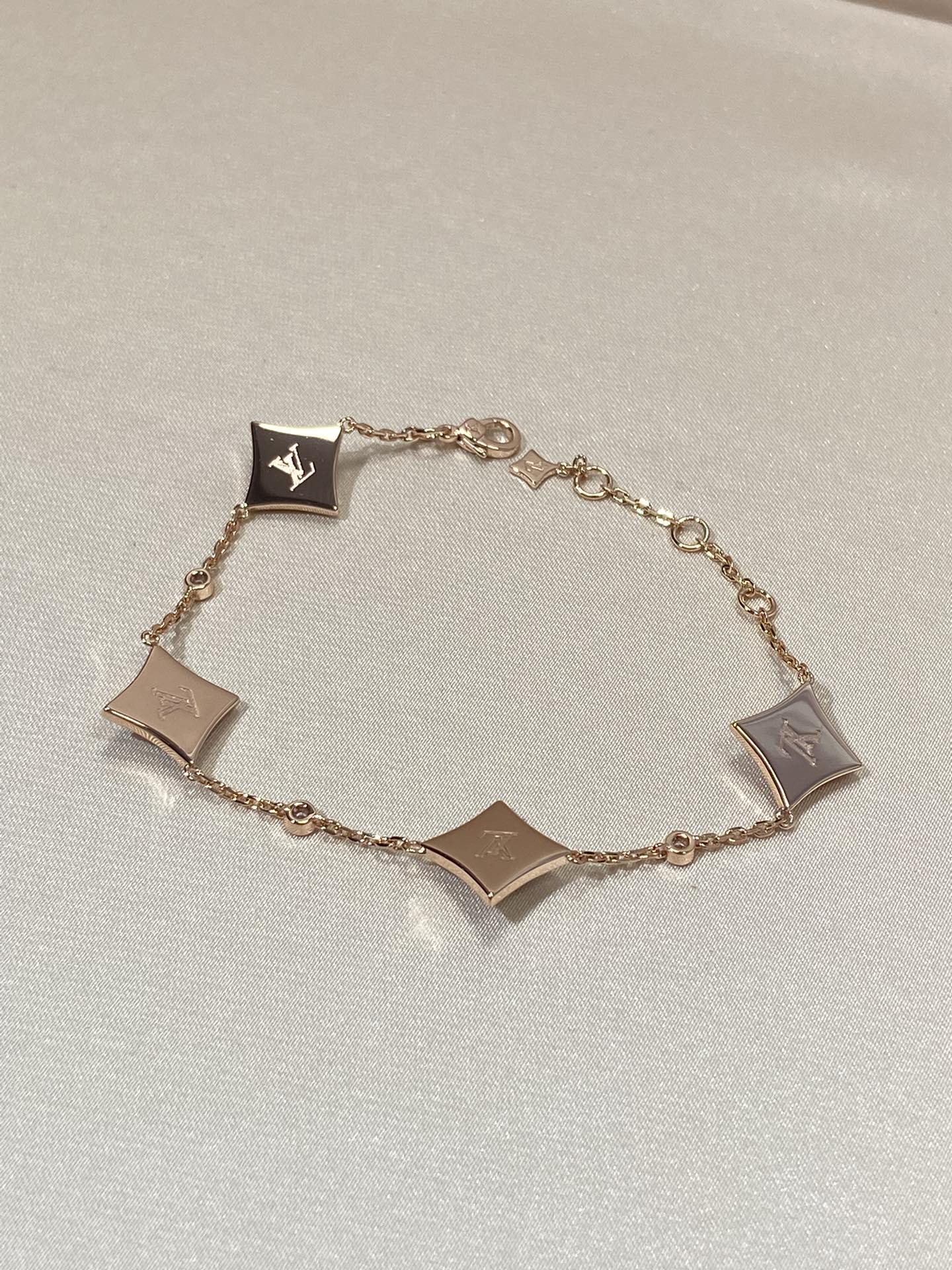 [BLAUE TRÄNEN]ARMBAND AUS ROTGOLD MIT 4 STERNENMOTIVEN UND DIAMANTEN